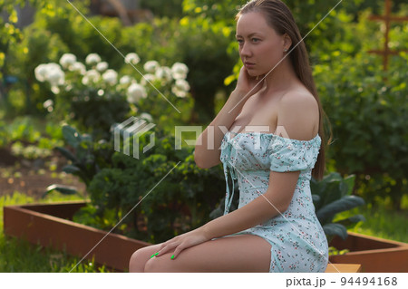 Sensitive woman sitting in garden Sensitive woman sitting in garden 94494168