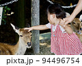 奈良公園の鹿と戯れる幼児のイメージ 94496754
