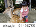 奈良公園の鹿と戯れる幼児のイメージ 94496755
