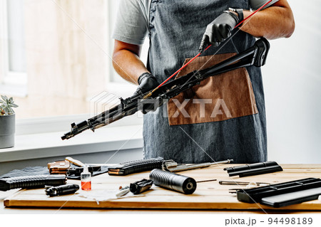 Close up of a gunsmith cleaning firearm barrel with ramrod brush Close up of a gunsmith cleaning firearm barrel with ramrod brush 94498189