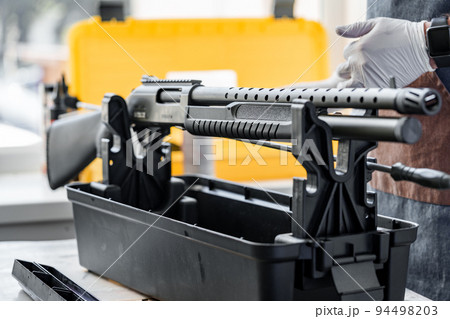 Automatic rifle on stand on the table of the weapons workshop Automatic rifle on stand on the table of the weapons workshop 94498203