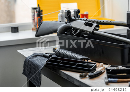 Automatic rifle on stand on the table of the weapons workshop. 94498212