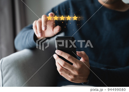 Close up of man customer giving a five star rating on smartphone. Review, Service rating, satisfaction, Customer service experience and satisfaction survey concept.. 94499080