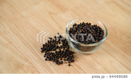 Black pepper in a glass bowl on the wooden table. food, spice, seasoning Concept. 94499086