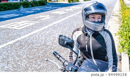 大型アメリカンバイクで横浜をツーリングする笑顔の女性ライダー 94499158