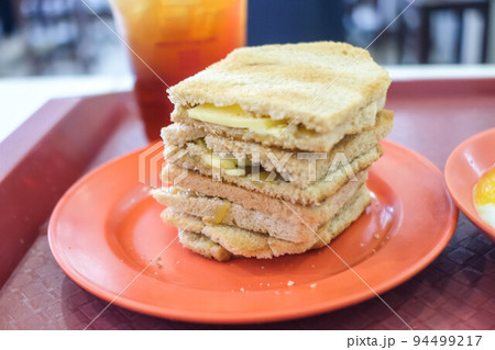 Kaya Toast, slices of toast with butter and kaya, served with ice tea and soft-boiled eggs. Kaya Toast, slices of toast with butter and kaya, served with ice tea and soft-boiled eggs. 94499217
