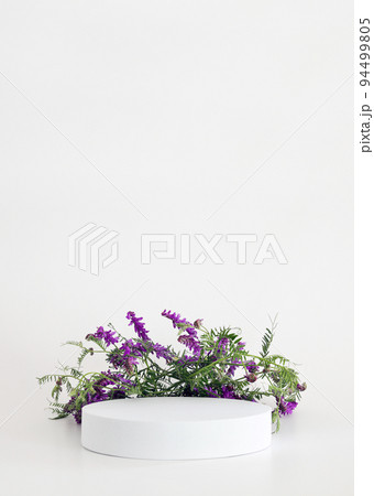 White podium on the white background with flowers. Podium for product, cosmetic presentation. Creative mock up. Pedestal or platform for beauty products. 94499805