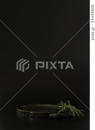 Black podium on the black background with tropical leaves and spa rocks. Podium for product, cosmetic presentation. Creative mock up. Pedestal or platform for beauty products. Black podium on the black background with tropical leaves and spa rocks. Podium for product, cosmetic presentation. Creative mock up. Pedestal or platform for beauty products. 94499806