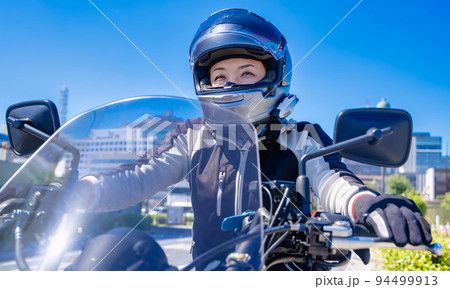 大型アメリカンバイクで横浜をツーリングする笑顔の女性ライダー 94499913