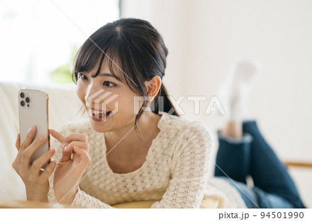 スマホ・スマートフォンを見る笑顔の女性 94501990