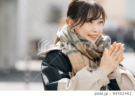 コートを着た笑顔の女性 94502462