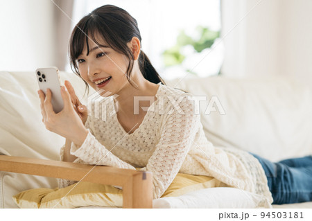 スマホ・スマートフォンを見る笑顔の女性 スマホ・スマートフォンを見る笑顔の女性 94503181