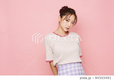スポーティなファッションをした若い女性のピンク背景のポートレート スポーティなファッションをした若い女性のピンク背景のポートレート 94503491
