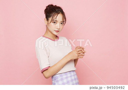 スポーティなファッションをした若い女性のピンク背景のポートレート スポーティなファッションをした若い女性のピンク背景のポートレート 94503492