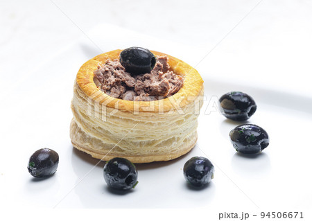 puff pastry filled with terrine served with black olives 94506671