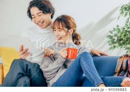 タブレットを見る若い男女 94506883
