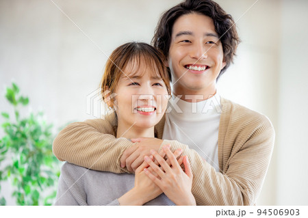 笑顔で寄り添う若い夫婦 94506903