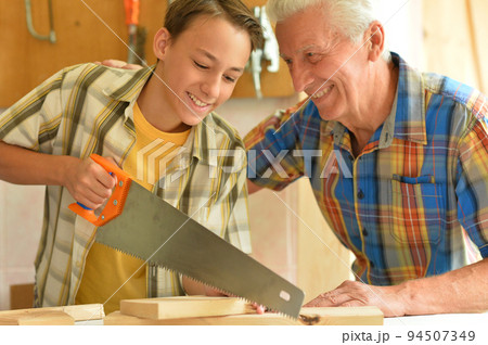 Senior carpenter and his grandson in the workshop 94507349