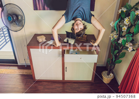 A man stands on his hands upside down in the living room 94507368
