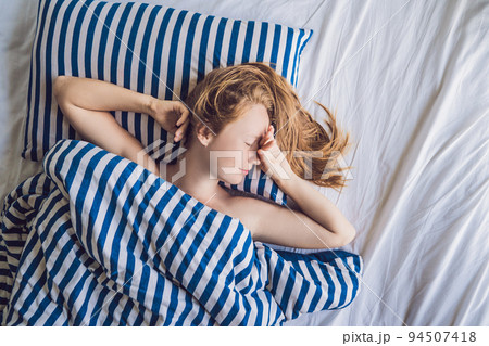 Beautiful young woman lying down in bed and sleeping. Do not get enough sleep concept 94507418