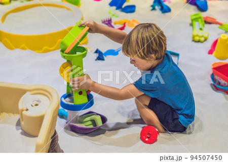 Boy playing with sand in preschool. The development of fine motor concept. Creativity Game concept Boy playing with sand in preschool. The development of fine motor concept. Creativity Game concept 94507450