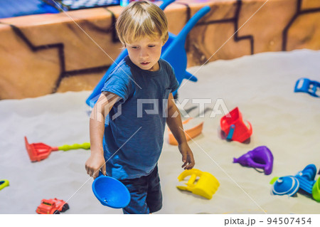 Boy playing with sand in preschool. The development of fine motor concept. Creativity Game concept Boy playing with sand in preschool. The development of fine motor concept. Creativity Game concept 94507454