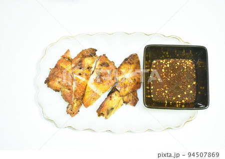 grilled chicken wing on plate dipping with spicy sauce in white background 94507869