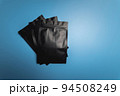 Zipper on plastic black matte bags, close-up lie on a blue background 94508249