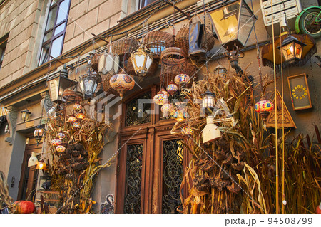 Cafe entrance decorated in Halloween style, with beautiful pumpkins, dried flowers, crows and antiques 94508799