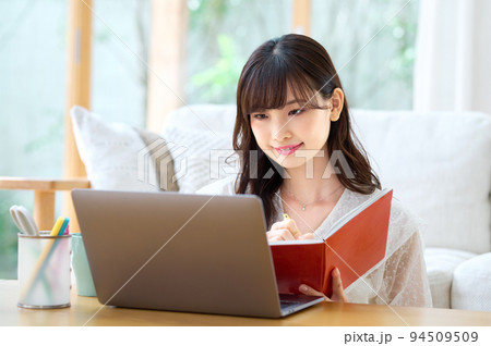 リビングでテレワーク中の若い女性 リビングでテレワーク中の若い女性 94509509