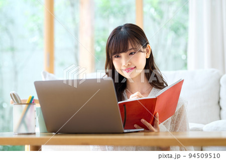 リビングでテレワーク中の若い女性 リビングでテレワーク中の若い女性 94509510