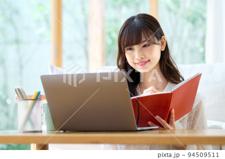 リビングでテレワーク中の若い女性 94509511