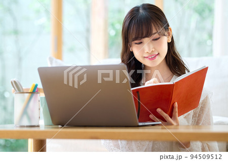 リビングでテレワーク中の若い女性 リビングでテレワーク中の若い女性 94509512