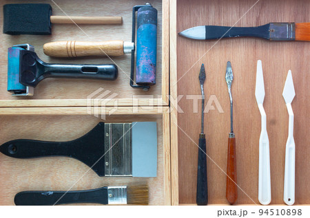 Art and craft DIY tools box. Rubber roller, foam brush, knife palette and paint brush on wooden tray. 94510898