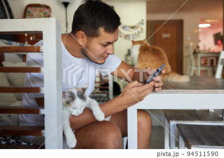 Young man in t shirt holding a cat. Young man in t shirt holding a cat. 94511590