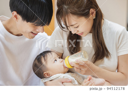 赤ちゃんにミルクをあげる夫婦 94512178