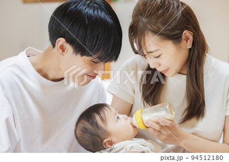 赤ちゃんにミルクをあげる夫婦 赤ちゃんにミルクをあげる夫婦 94512180