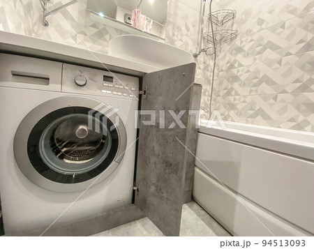modern, stylish bath in a residential apartment. a huge sink made of white material, a stone countertop. there is a washing machine inside the closet. modern technology modern, stylish bath in a residential apartment. a huge sink made of white material, a stone countertop. there is a washing machine inside the closet. modern technology 94513093