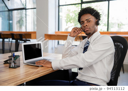 Focused male office worker with headset Focused male office worker with headset 94513112