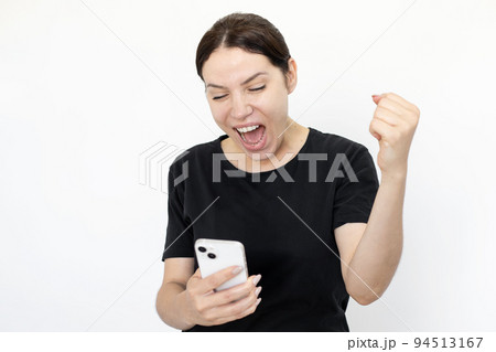 Excited woman looking at phone and celebrating victory 94513167