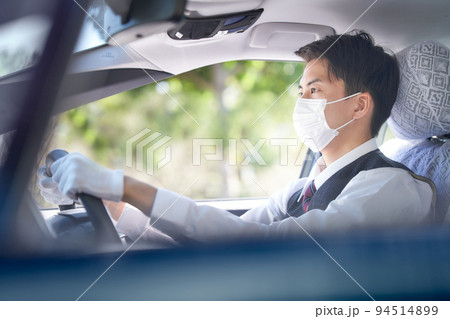 マスクをつけて運転するタクシードライバー 94514899