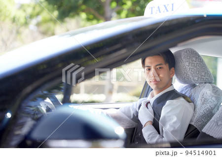 笑顔で視線を向ける若いタクシードライバー 94514901