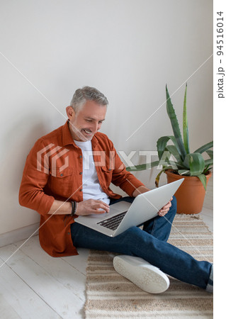 Bearded man in terracotta shirt working from home Bearded man in terracotta shirt working from home 94516014