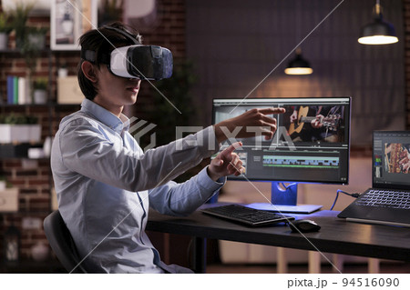 Male videographer editing movie montage with virtual reality glasses, using multimedia production software to create footage. Edit with color grading and visual effects, working with vr goggles. Male videographer editing movie montage with virtual reality glasses, using multimedia production software to create footage. Edit with color grading and visual effects, working with vr goggles. 94516090