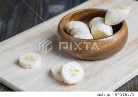 sliced ripe banana on a wooden board, close up 94516579
