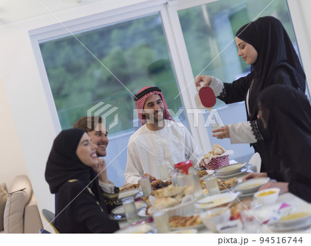 Eid Mubarak Muslim family having Iftar dinner drinking water to break feast. Eating traditional food during Ramadan feasting month at home. The Islamic Halal Eating and Drinking at modern western Isla Eid Mubarak Muslim family having Iftar dinner drinking water to break feast. Eating traditional food during Ramadan feasting month at home. The Islamic Halal Eating and Drinking at modern western Isla 94516744