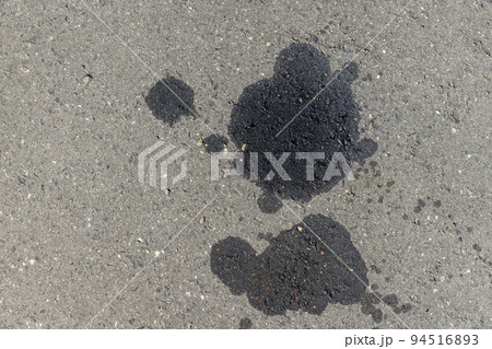 A road for vehicles covered with stains and pollution from oil and fuel of cars 94516893