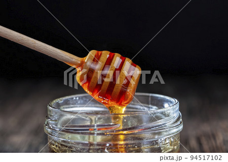 Sweet bee honey in a transparent glass jar Sweet bee honey in a transparent glass jar 94517102