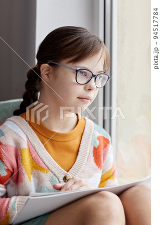 Girl With Down Syndrome By Window 94517784
