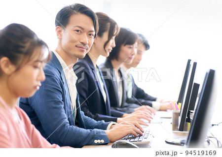 デスクワークをしながら視線を向けるビジネスパーソン デスクワークをしながら視線を向けるビジネスパーソン 94519169